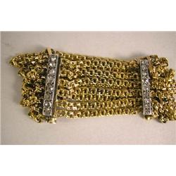 A 14K YELLOW GOLD SIX CHAIN LINK BRACELET HELD TOGETHER WITH FOUR WHITE GOLD BARS SET WITH DIAMONDS