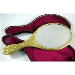 AN ENGRAVED BRASS VANITY MIRROR