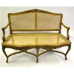 A LOUIS XV CARVED WALNUT CANED SEAT CANAPE
