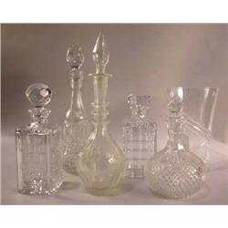 A GROUP OF FIVE ASSORTED COLORLESS GLASS DECANTERS
