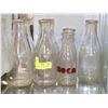Image 1 : SHELF OF VINTAGE ROUND MILK BOTTLES.