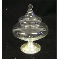 Une bonbonnière couverte en verre sur une base en argent.