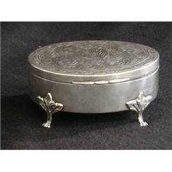 Une boîte à bijoux ovale en argent gravé de Birks, sur des pieds griffes.