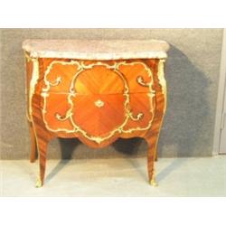Une commode bombée de style Louis XV en bois de placage, le dessus de marbre (brisé) surmontant deux