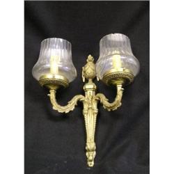 Une paire d’appliques de style Louis XVI en bronze doré à 2 branches de lumière à décor d’urnes supp