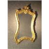 Image 1 : Un miroir en bois doré de style Louis XV à décor de feuillage.