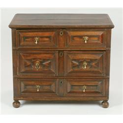 17th Century Oak Chest of Drawers a rectangular top above three panelled drawers raised on bun feet,