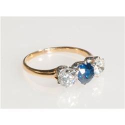 18k Yellow Gold And Platinum Ring set with a full cut sapphire (approx. 1.25ct.) flanked by 2 Europe