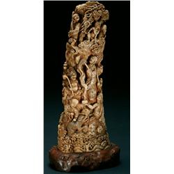 Ivory Okimono of Immortals comprising a columnar rock set with myriad figures, including oni, rakan,