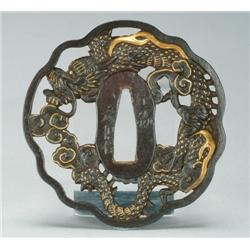Soten School Iron Tsuba with serpentine rim, in openwork with a two sided dragon, enriched with gold