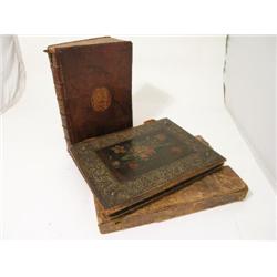 A leather case in the form of a book, with embossed gilt spine and coat of arms and a leather mounte