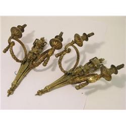 A pair of Neo Classical design gilt brass twin branch wall lights, the rams head backplates with urn