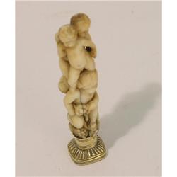 A 19th century ivory desk seal, the handle modelled as a Bacchus group of cherubs with gold mount an