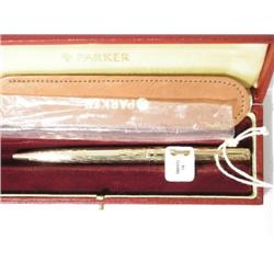 A Parker 9ct gold 'Presentation' ball point pen, with engine turned flame finish, in red presentatio