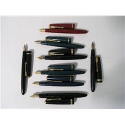 Four Parker Duofold fountain pens, with gold chevron band and arrow caps and black finish, and four 