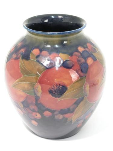 A Moorcroft Vase Pomegranate Ovoid Shape Design Against A Blue