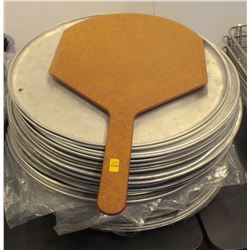 STACK OF PIZZA PANS AND GREASE TRAPS WITH A PIZZA