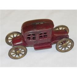 6 3/4" RED PAINTED CAST IRON AUTOMOBILE W/ PEOPLE STILL BANK BY AC WILLIAM