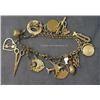 Image 1 : 14 K YELLOW GOLD CHARM BRACELET ADORNED WITH 16 GOLD CHARMS INCLUDING AN APPLE, "#1", SCISSORS, SAN 