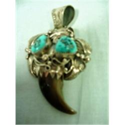 STERLING SILVER PENDANT INCLUDING A BEAR CLAW PENDANT SET WITH TWO TURQUOISE NUGGETS.