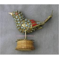 STERLING SILVER FIGURAL BIRD SCULPTURE DECORATED WITH TURQUOISE AND CORAL STONES AND SITTING ON A WO
