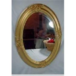 ANTIQUE OVAL MIRROR WITH ORNATE STATION DECORATION. 25" X 18"
