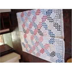 ANTIQUE QUILT IN A MODIFIED OCEAN WAVES PATTERN 79" X 61" WITH A WHITE BACK.