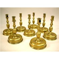 EIGHT NEARLY IDENTICAL CAST BRASS DOME-BASE CANDLESTICKS