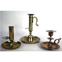 A GROUP OF THREE BRASS CHAMBERSTICKS