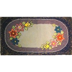 A POLYCHROME AND FLORAL DECORATED HOOKED RAG RUG