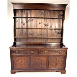 A CARVED AND FIGURED OAK WELSH STEP-BACK CUPBOARD