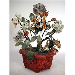 A CHINESE CINNABAR LACQUER JARDINIERE CONTAINING A HARDSTONE PLANT