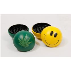 LOT OF TWO GRINDERS (HAPPY FACE, PLANT LEAF)