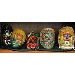 Five colorful clay and wooden decorative masks.  