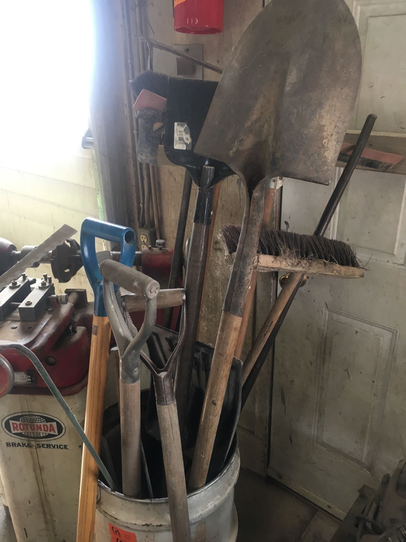 Barrel w/brooms, axe, crowbar, sledge hammers, rakes, squeegee, shovels