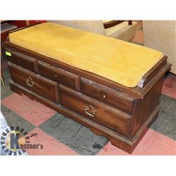 WOOD STORAGE BENCH WITH ORANGE CUSHION.