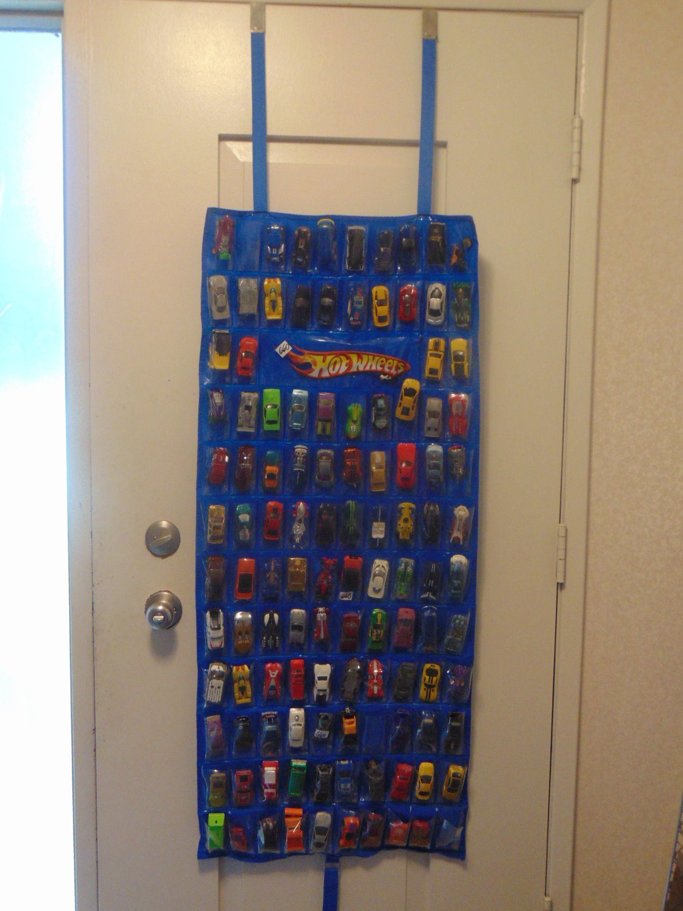 OVER 100 MATCHBOX CARS ON DOOR MOUNT RACK WITH SLEEVES