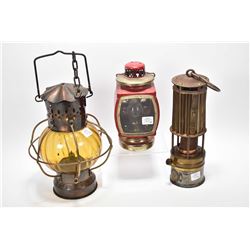 Three vintage kerosene lamps including one marked "Industrial Rubber Product Ltd. London, Indupro la