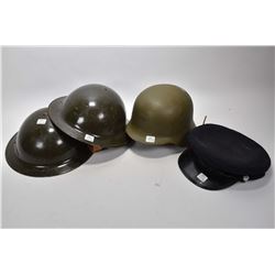 Three vintage army helmets and an officer's hat