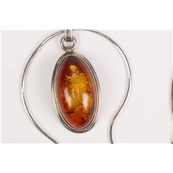 18kt white gold hexagonal snake 18" chain and a sterling silver, oval shaped cabochon amber pendant.