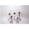 Image 1 : Set of five matching and graduated sized colourless press glass oil lamps including one turning purp