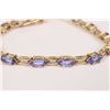 Image 1 : Ladies 14kt yellow gold, tanzanite gemstone and diamond bracelet. Set with 0.35ct of baguette cut wh