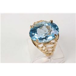 Ladies 10kt yellow gold ring set with large faceted oval cut blue topaz gemstone