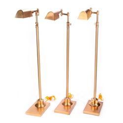 Three brass floor lamps.