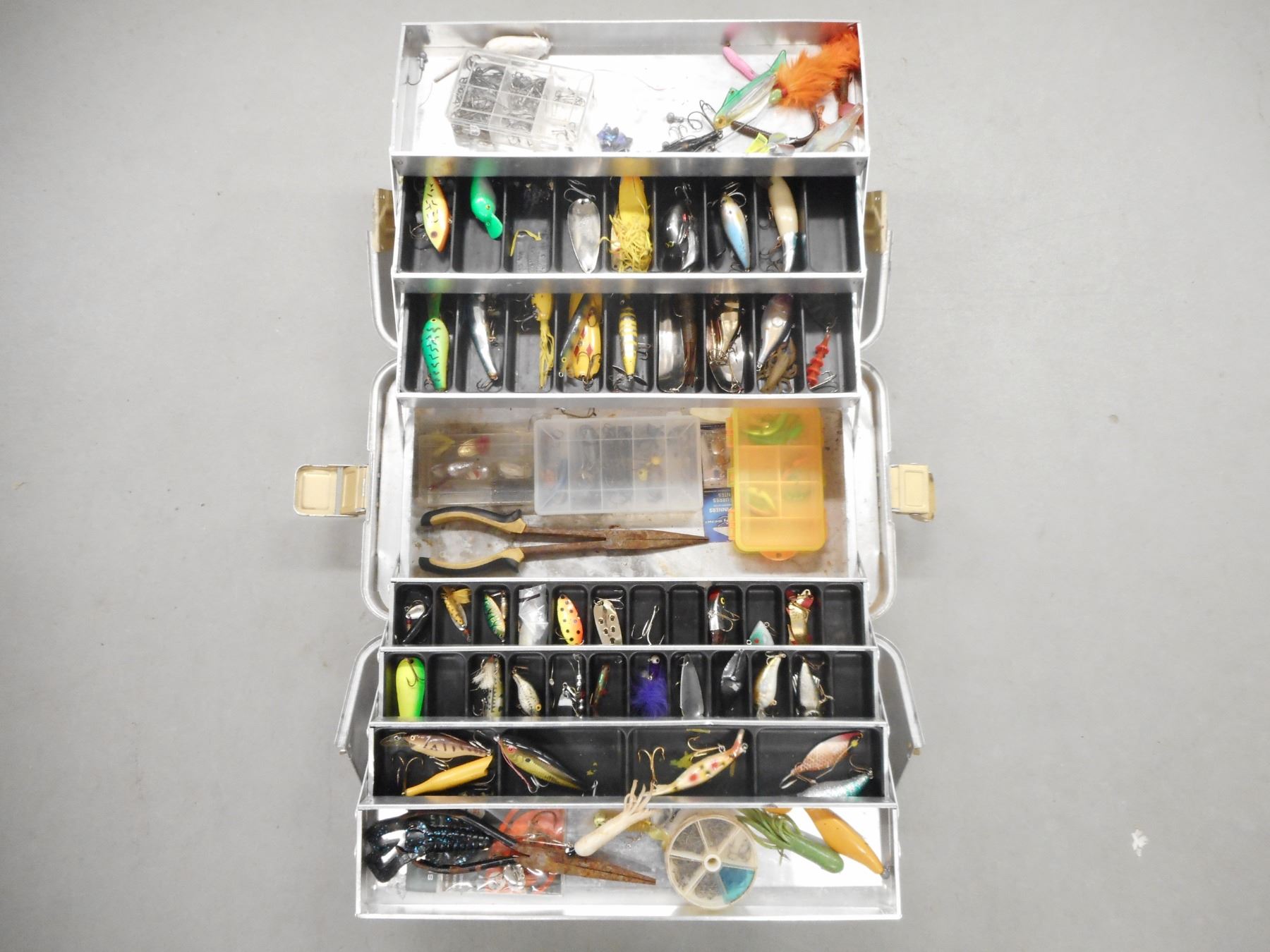 TACKLE BOX WITH ASSORTED FISHING LURES AND HOOKS.