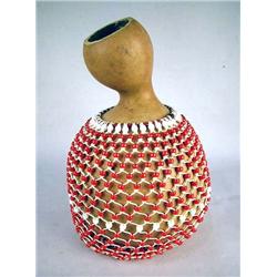AN AFRICAN SHEKERE Covered with red and white beads, wear, 15"h