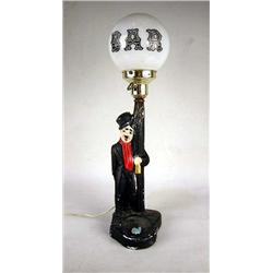 A CHARLIE CHAPLIN PAINTED BAR LAMP Losses, together with a 35mm photo depicting Dizzy and a partiall