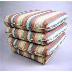 A MODERN STRIPED UPHOLSTERED OTTOMAN ON CASTERS Together with a circular beige leather footstool and