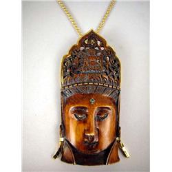 A WOOD CARVING OF AN INDIAN WOMAN With latticework cutout crown, framed in 18K yellow gold earrings,
