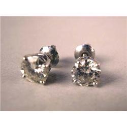 A PAIR OF 14K WHITE GOLD DIAMOND STUD EARRINGS Each with a round brilliant cut diamond, one with est